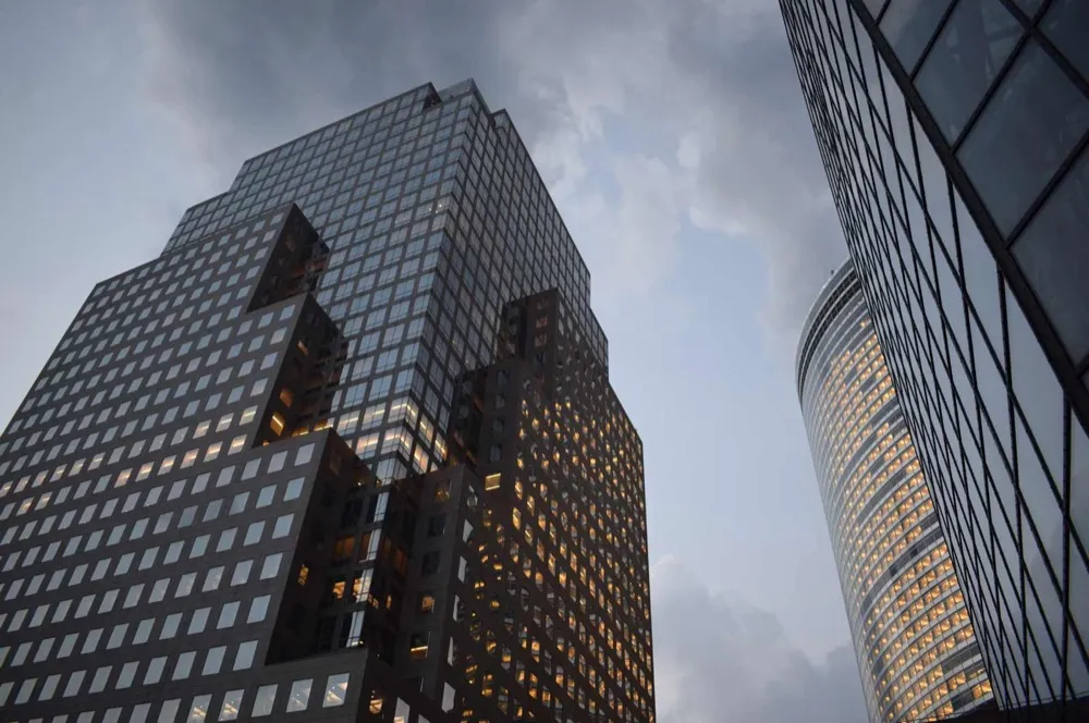 Corporate glass office towers viewed from below at dusk